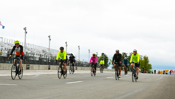 fans riding bicycles around watkins glen international
